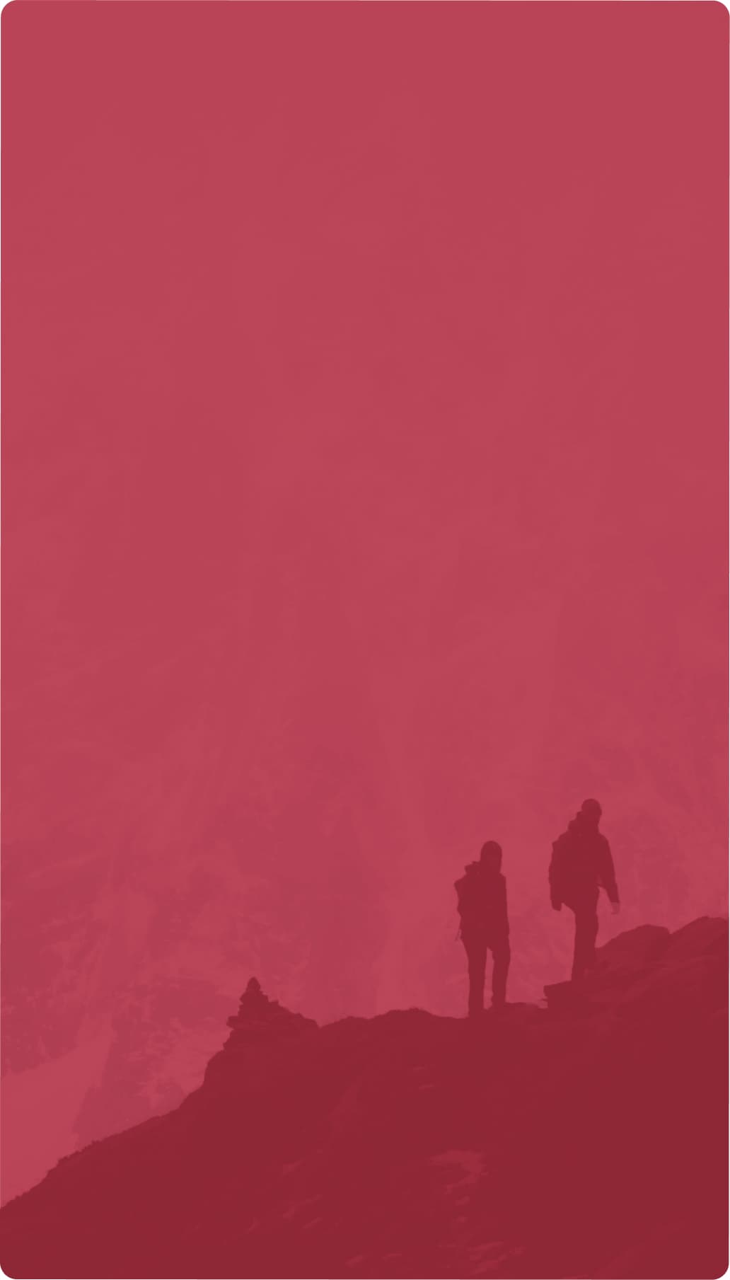 Two silhouetted hikers walks on a rocky ridge, set against a monochromatic red-tinted mountainous background.