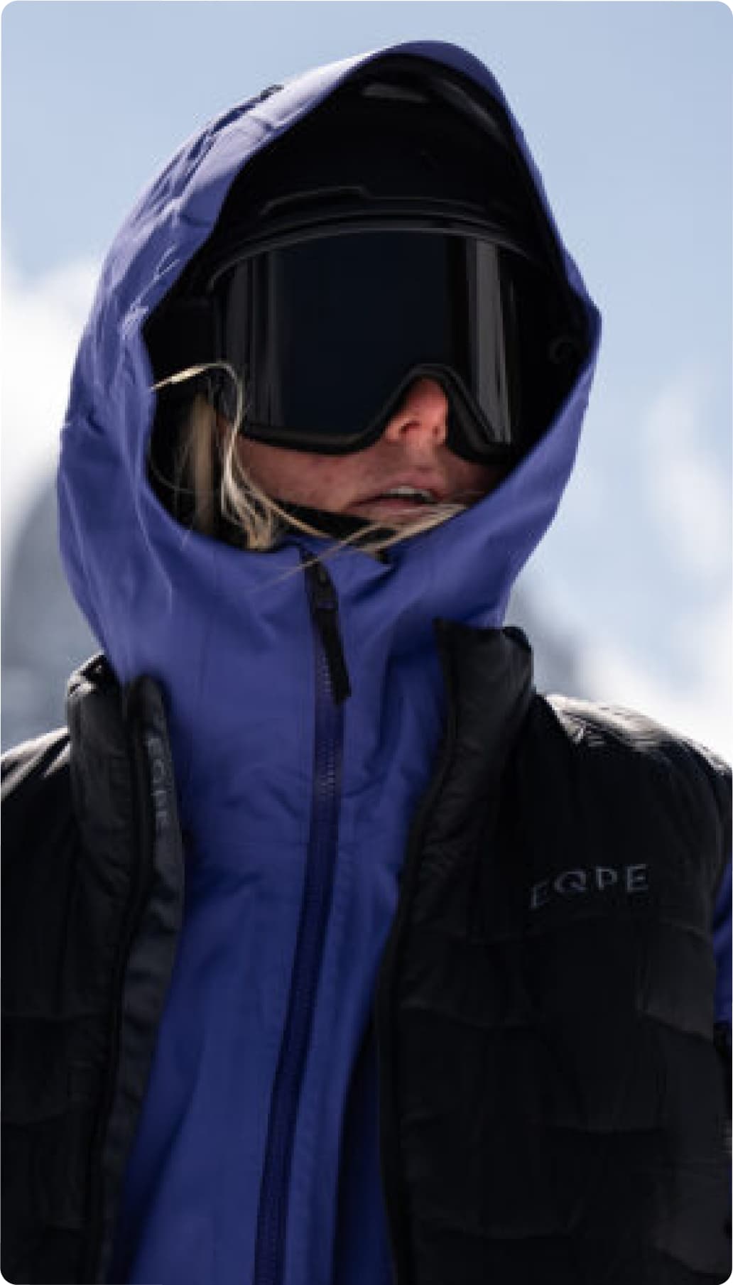 Skier in purple jacket and black ski goggles.