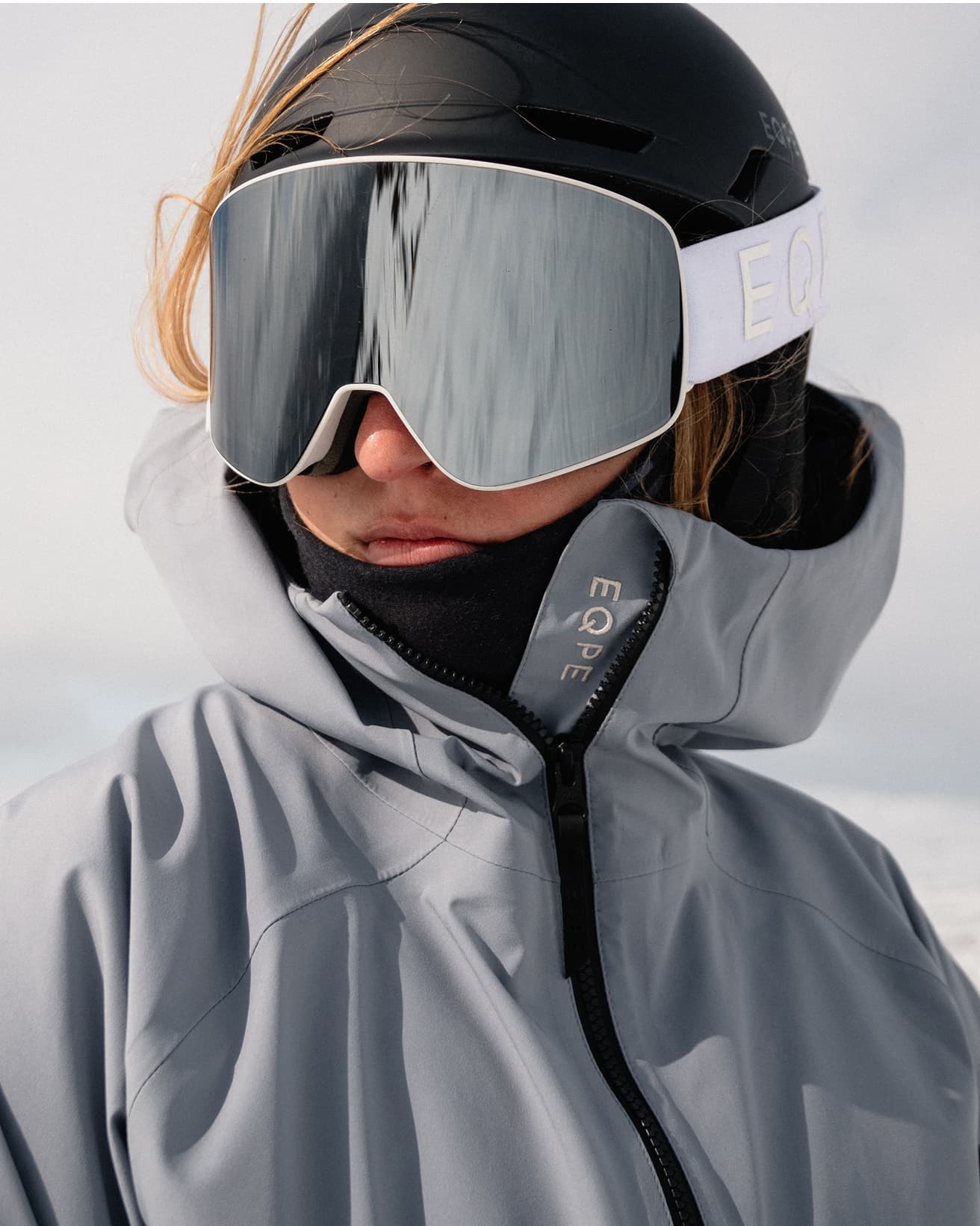 Person in blue ski jacket and large reflective goggles