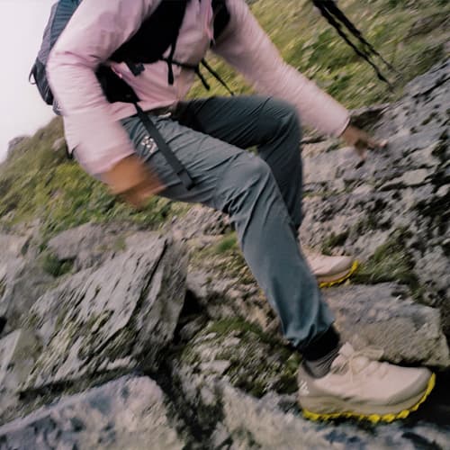 A woman in hiking clothes hiking down a cliff
