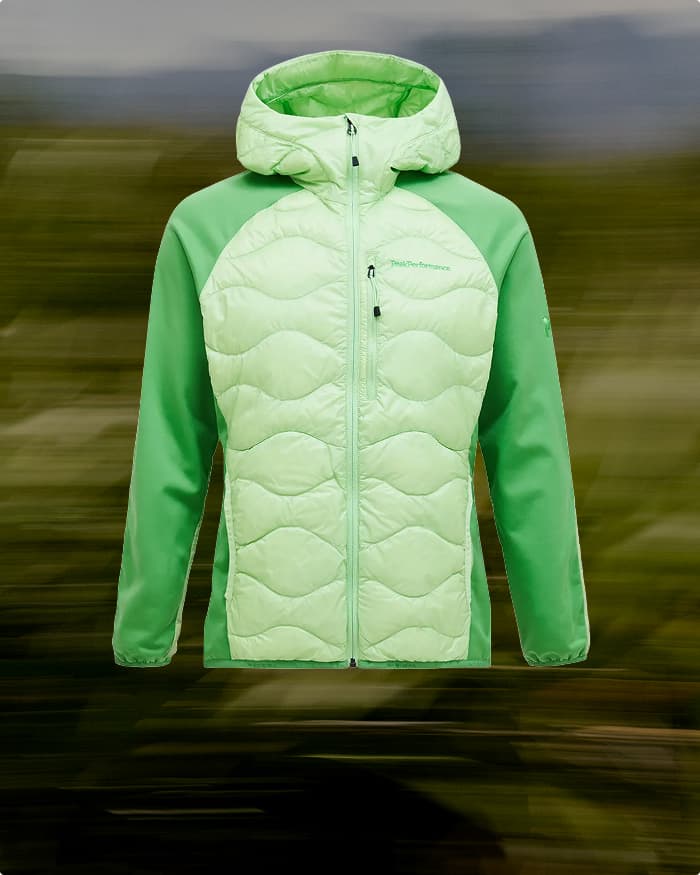 Light green quilted jacket with a hood, featuring a full zipper and contrasting green sleeves, displayed against a blurred background.