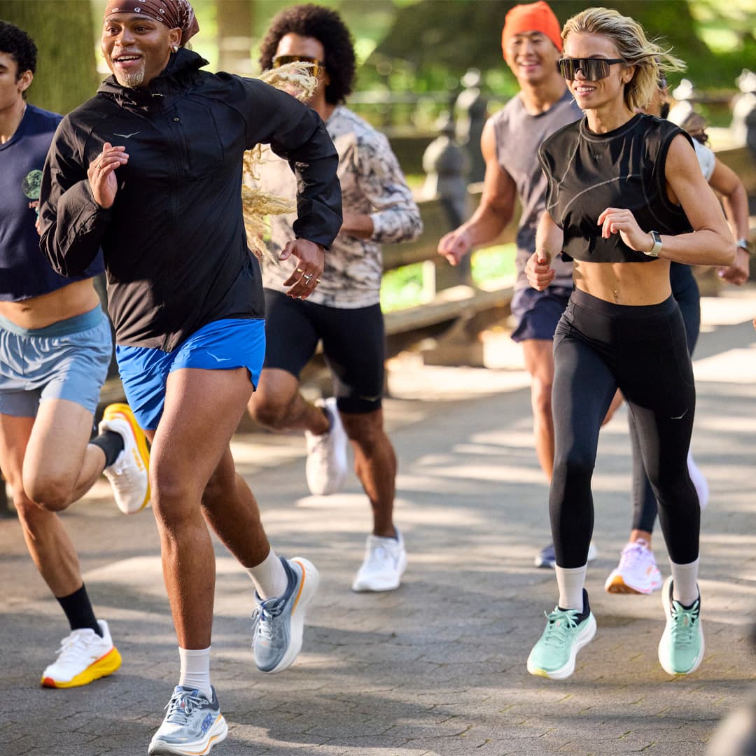 A group of people jogging together in a park.
