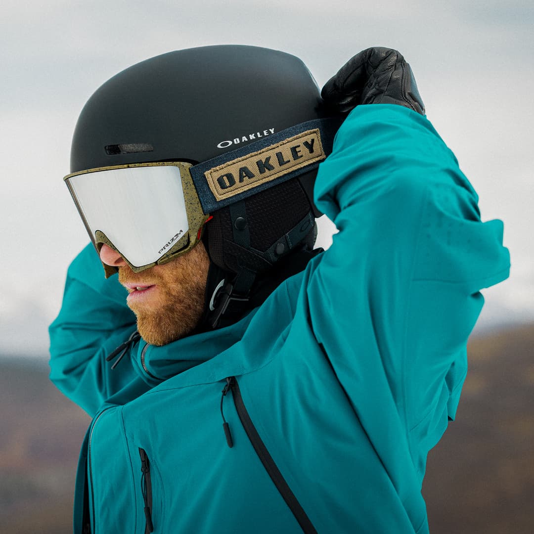 Man wearing Oakley helmet and googles against a blurry background