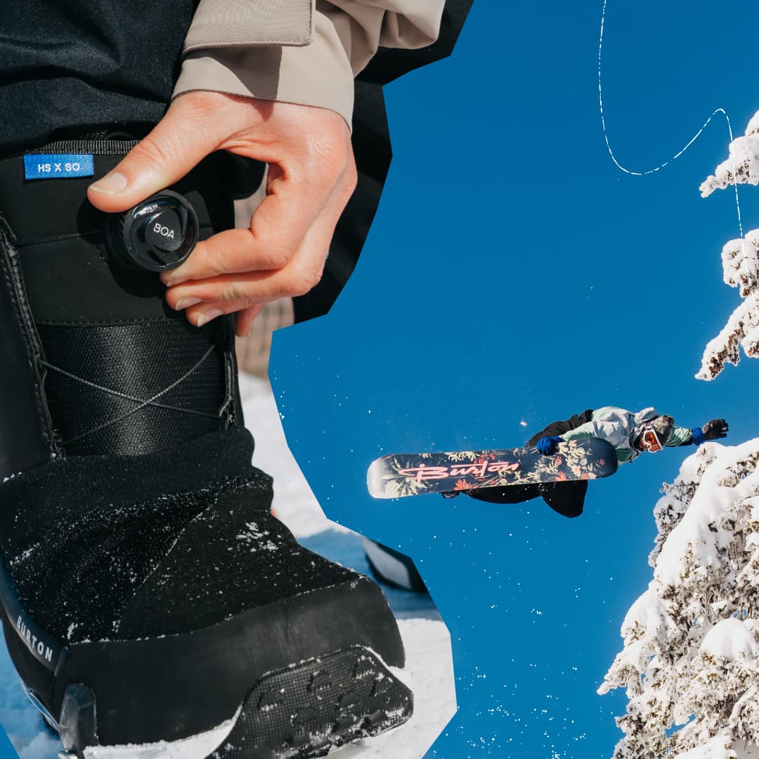 Close-up of a snowboard boot being adjusted, with a snowboarder performing a jump against a bright blue sky and snow-covered trees.