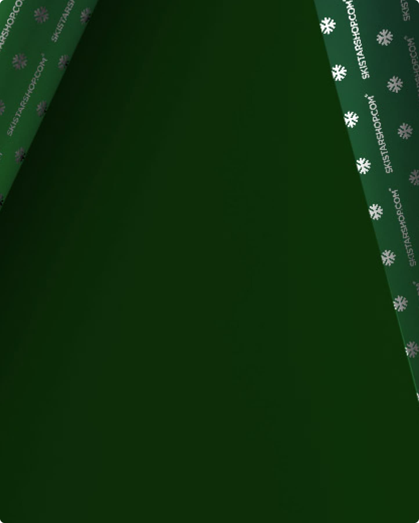 Dark green wrapping paper with a folded corner, revealing a pattern of white snowflakes.