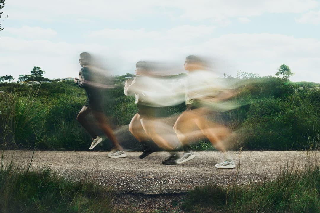 Three people running on a gravel road