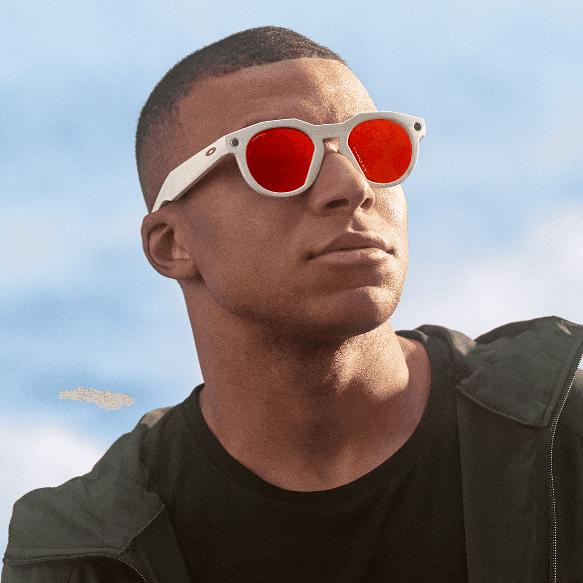Person wearing white-framed sunglasses with red lenses, looking into the distance against a blue sky background.