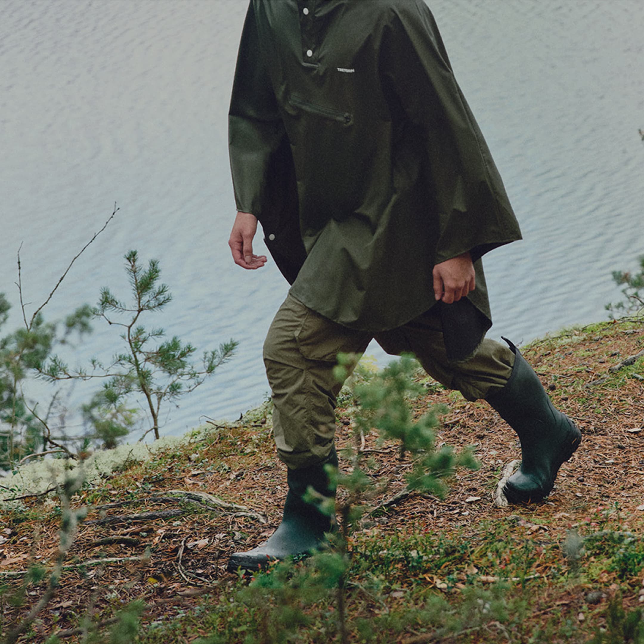 Person walking in green rubber boots on a trail
