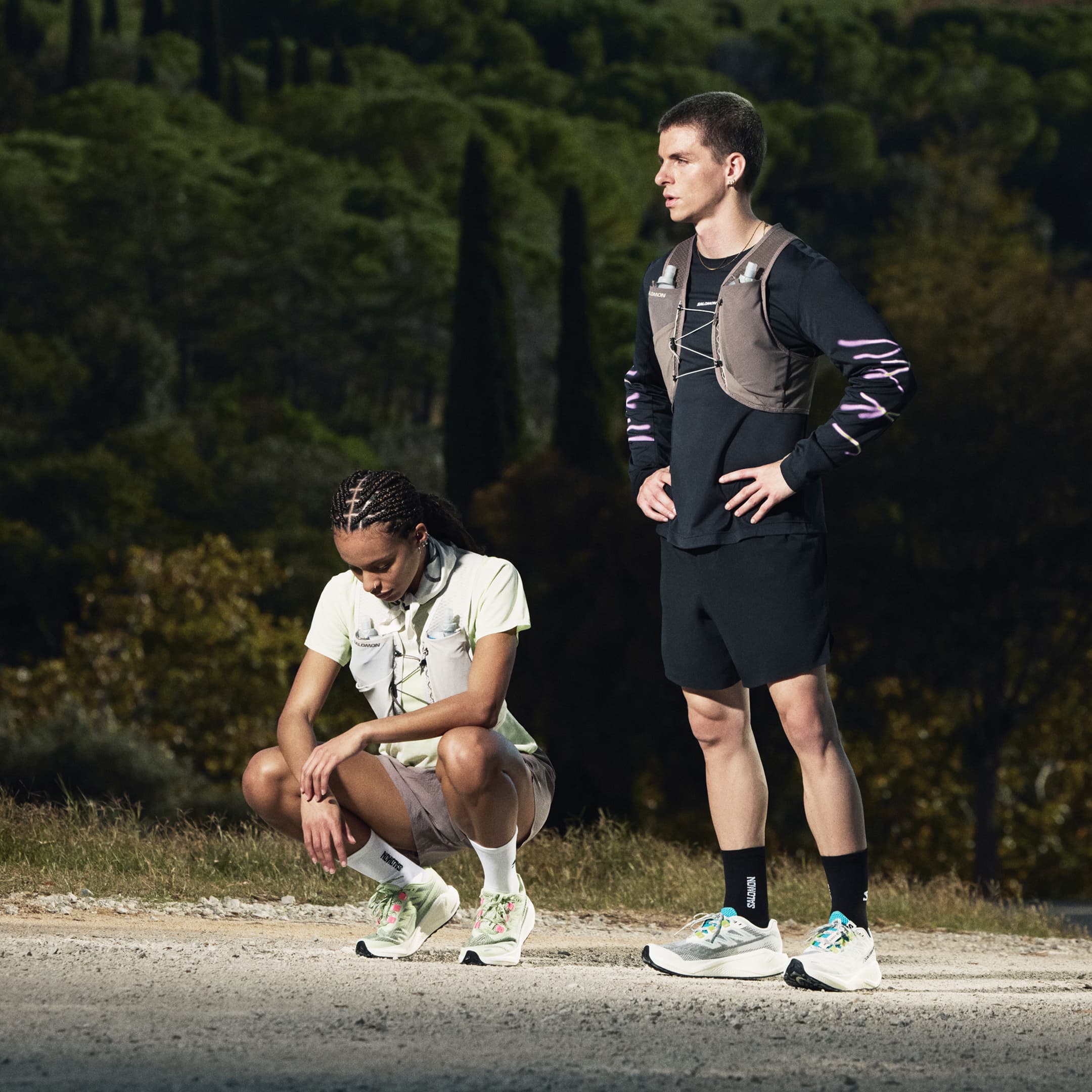 Two runners standing in front of a forest