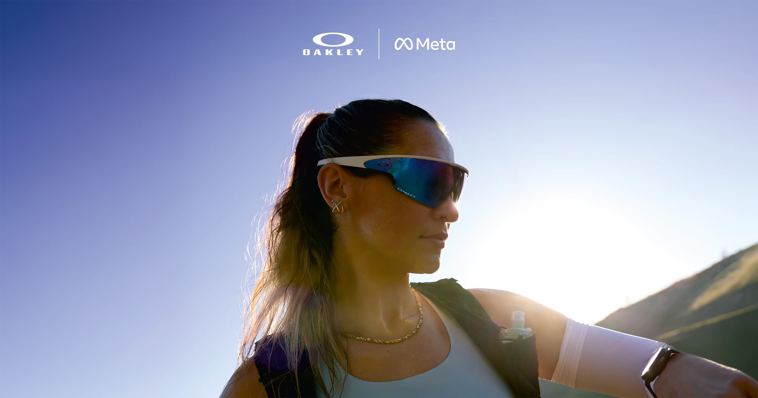 Woman in AI glasses from Oakley, with Oakleys and Metas logos in white