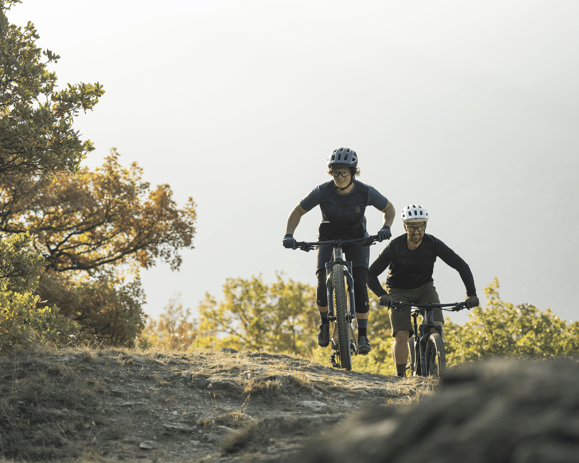 Two people mountain biking on a trail.