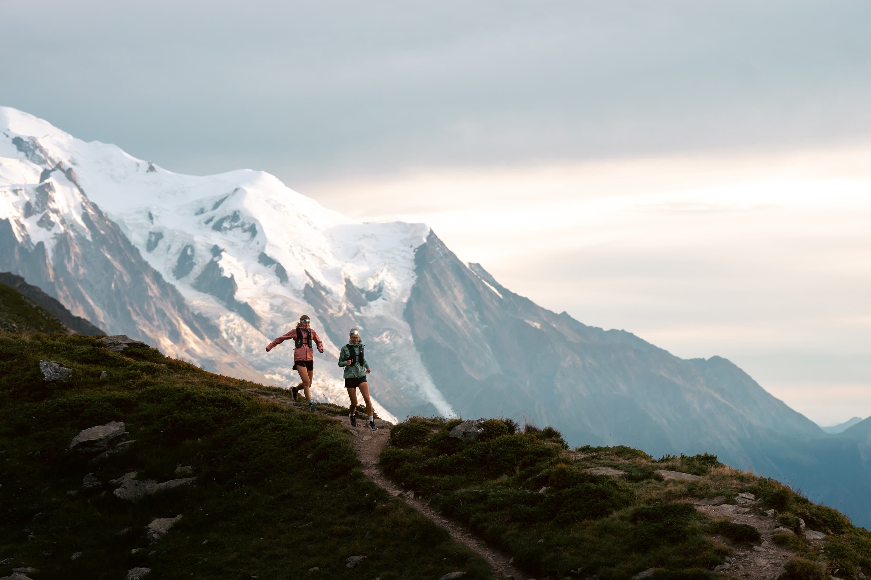 Two people running with headlamps in the mountains
