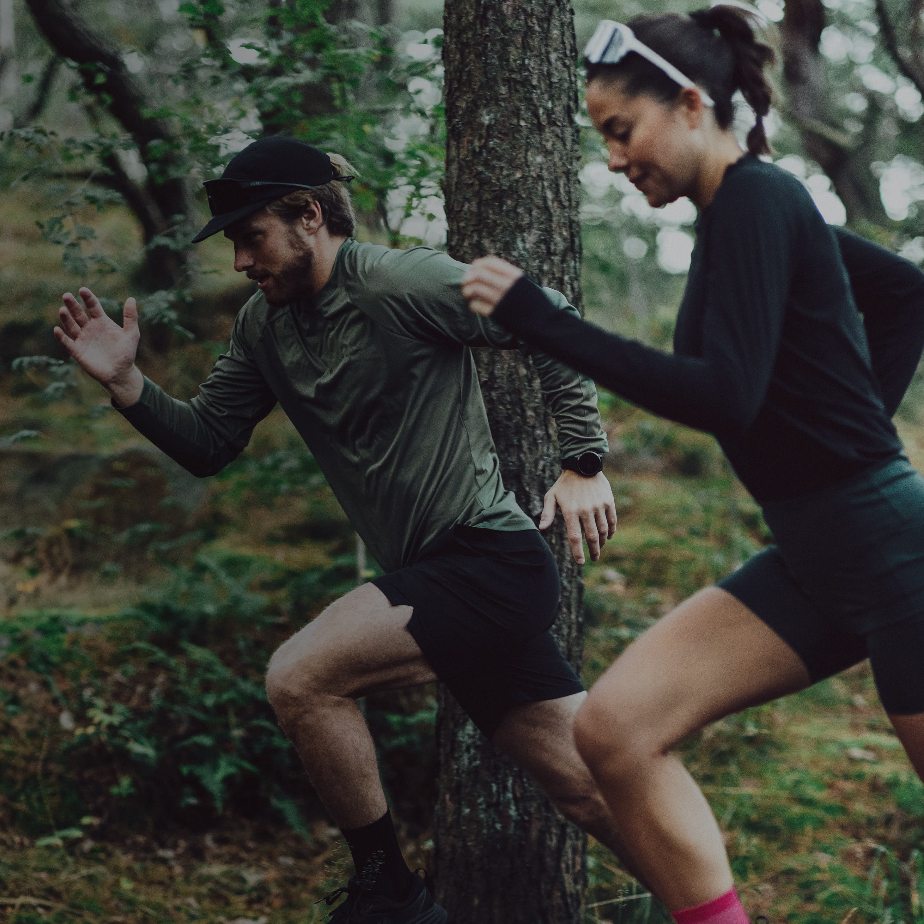 A man and a woman running in the woods
