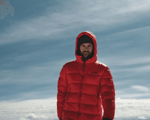 A person in a red puffer jacket and black beanie.