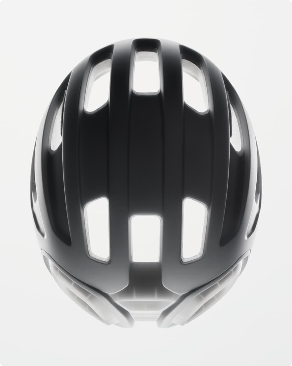 Black bike helmet with multiple elongated vents, viewed from above, against a plain white background.